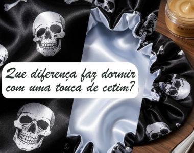 "Uma touca de cetim preta com padrão de caveiras prateadas e forro interior em cetim branco claro. A touca está pousada numa superfície de madeira ao lado de um boião de máscara capilar e uma colher metálica. Sobre a imagem, um balão de texto pergunta: 'Que diferença faz dormir com uma touca de cetim?'."